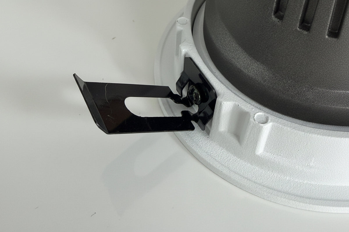Close-up of a black blade attached to a gray circular object on a white background