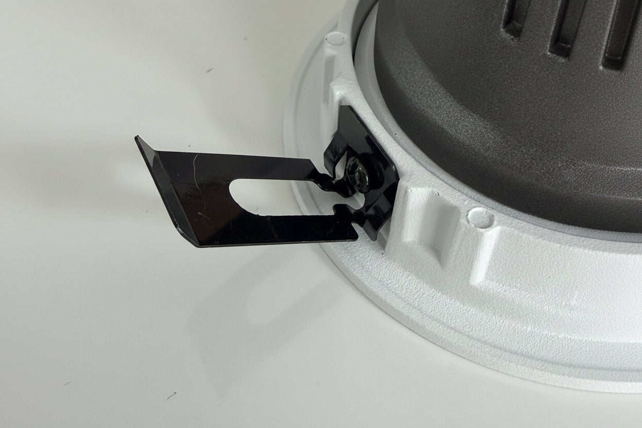 Close-up of a black blade attached to a gray circular object on a white background