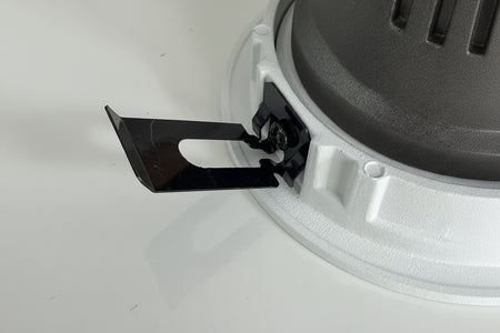 Close-up of a black blade attached to a gray circular object on a white background